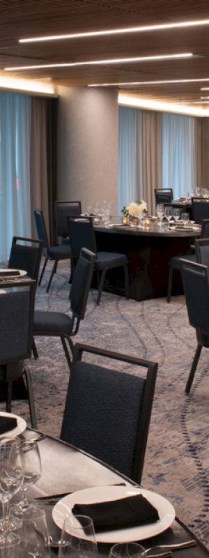 The image shows an elegant banquet hall with round tables set for a formal event or dinner.